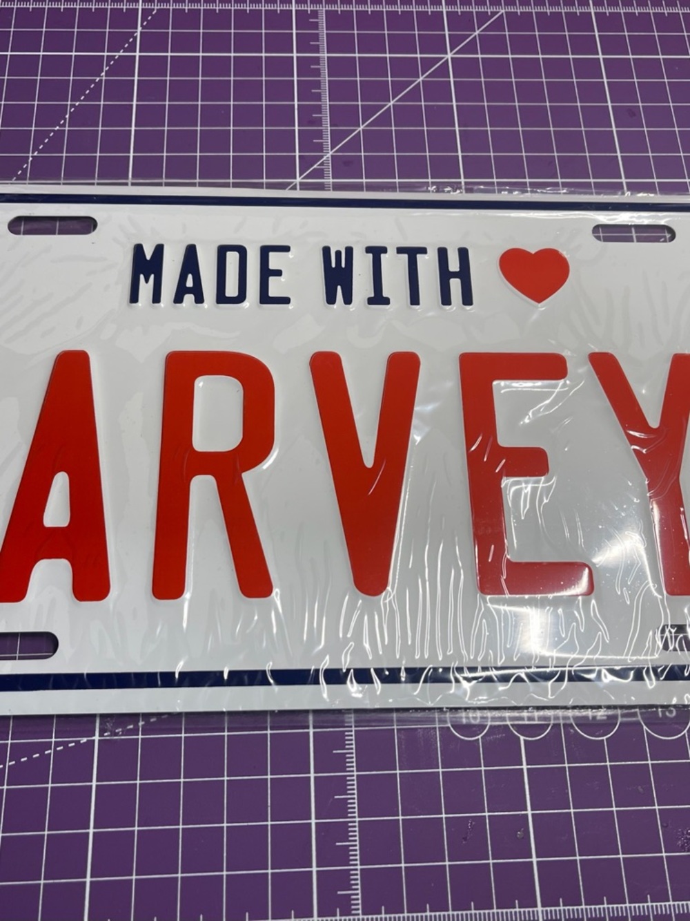 Harveys White License Plate Sign with Red Lettering and Navy Accents